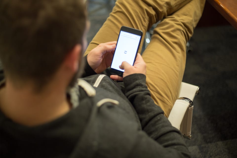 Eine Person sitzt mit einem Smartphone und schaut sich ein Marktplatzangebot an, so wie die meisten Kunden